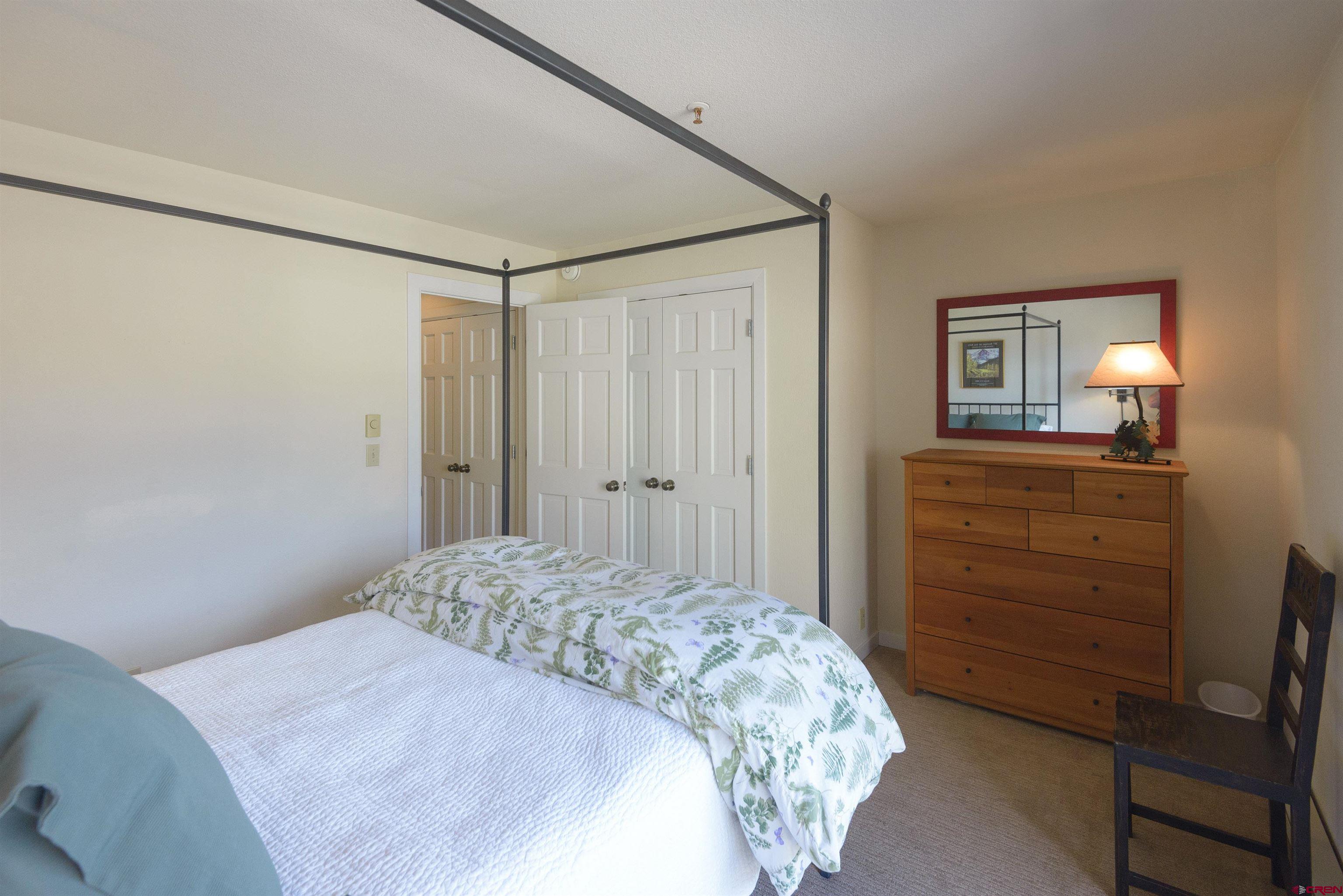 12 Snowmass Road, Unit 416 Crested Butte, CO 81225 - Photo 17 of 35 a bedroom with a bed and a dresser in it