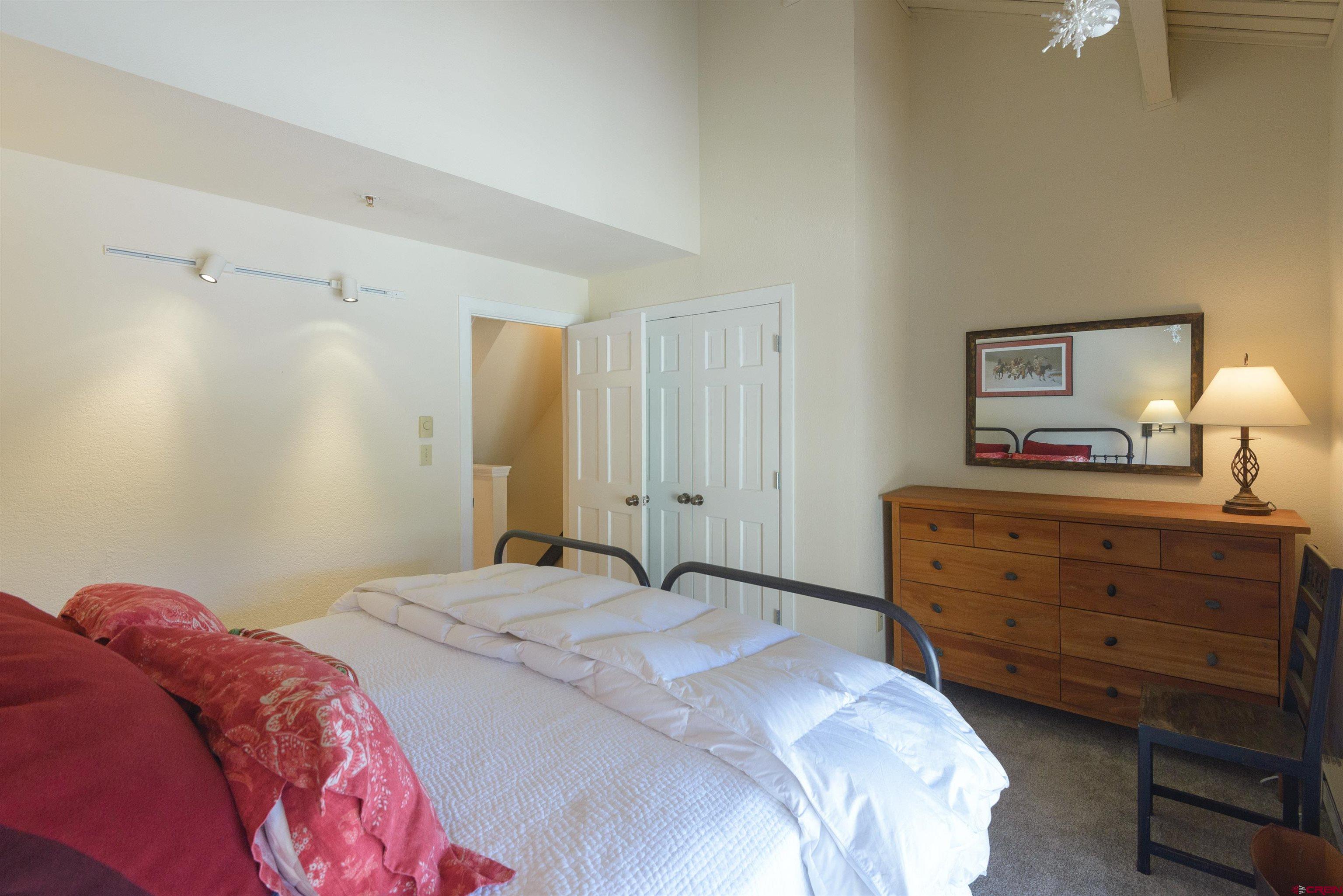 12 Snowmass Road, Unit 416 Crested Butte, CO 81225 - Photo 26 of 35 a bedroom with a bed and a mirror on dresser