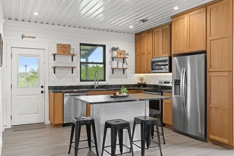 a kitchen with stainless steel appliances a sink stove refrigerator and cabinets
