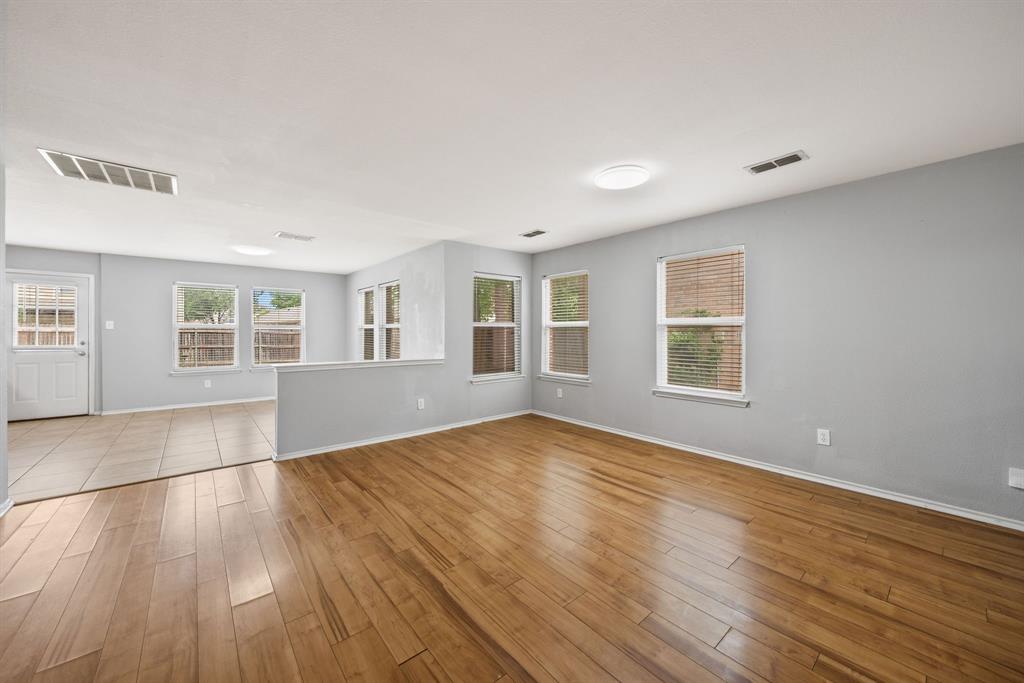 601 Amy Way Euless, TX 76039 - Photo 10 of 40 an empty room with wooden floor and windows