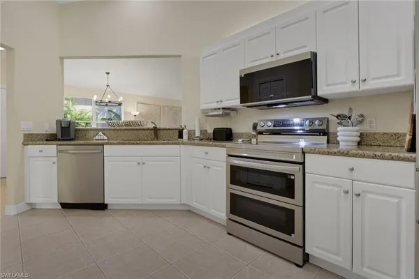 a kitchen with cabinets stainless steel appliances and a counter space