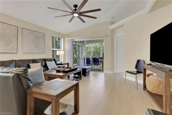 a living room with furniture a flat screen tv and a large window