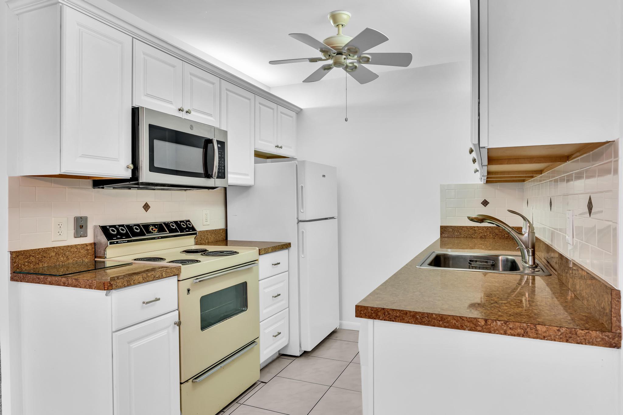 2066 Exeter Boca Raton, FL 33434 - Photo 11 of 60 a kitchen with stainless steel appliances granite countertop a sink stove and refrigerator