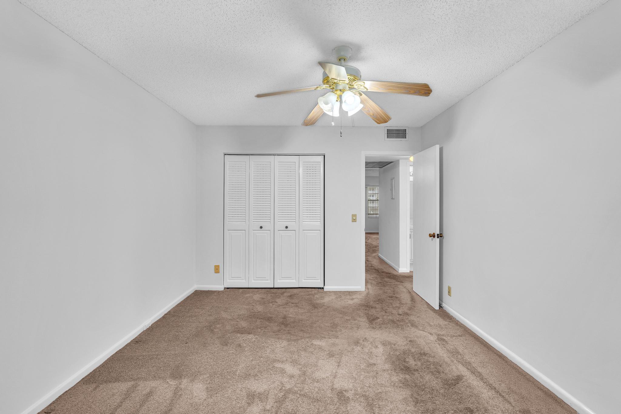 2066 Exeter Boca Raton, FL 33434 - Photo 20 of 60 an empty room with a chandelier fan and closet