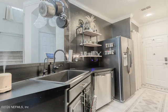 a kitchen with stainless steel appliances granite countertop a sink and refrigerator