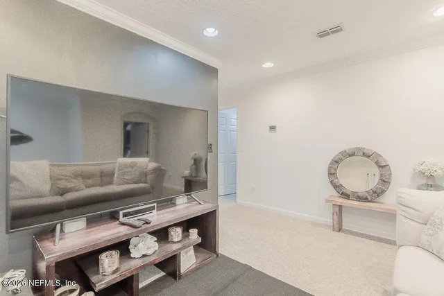 a view of a hallway with a livingroom and a bathroom
