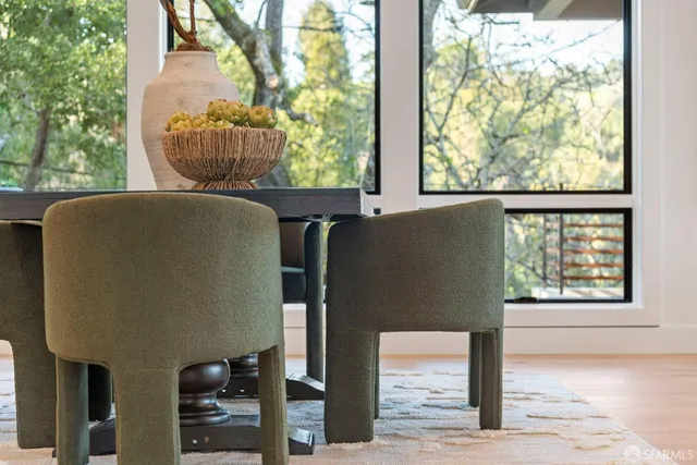 a kitchen with stainless steel appliances kitchen island granite countertop a stove a sink a refrigerator and white cabinets with wooden floor