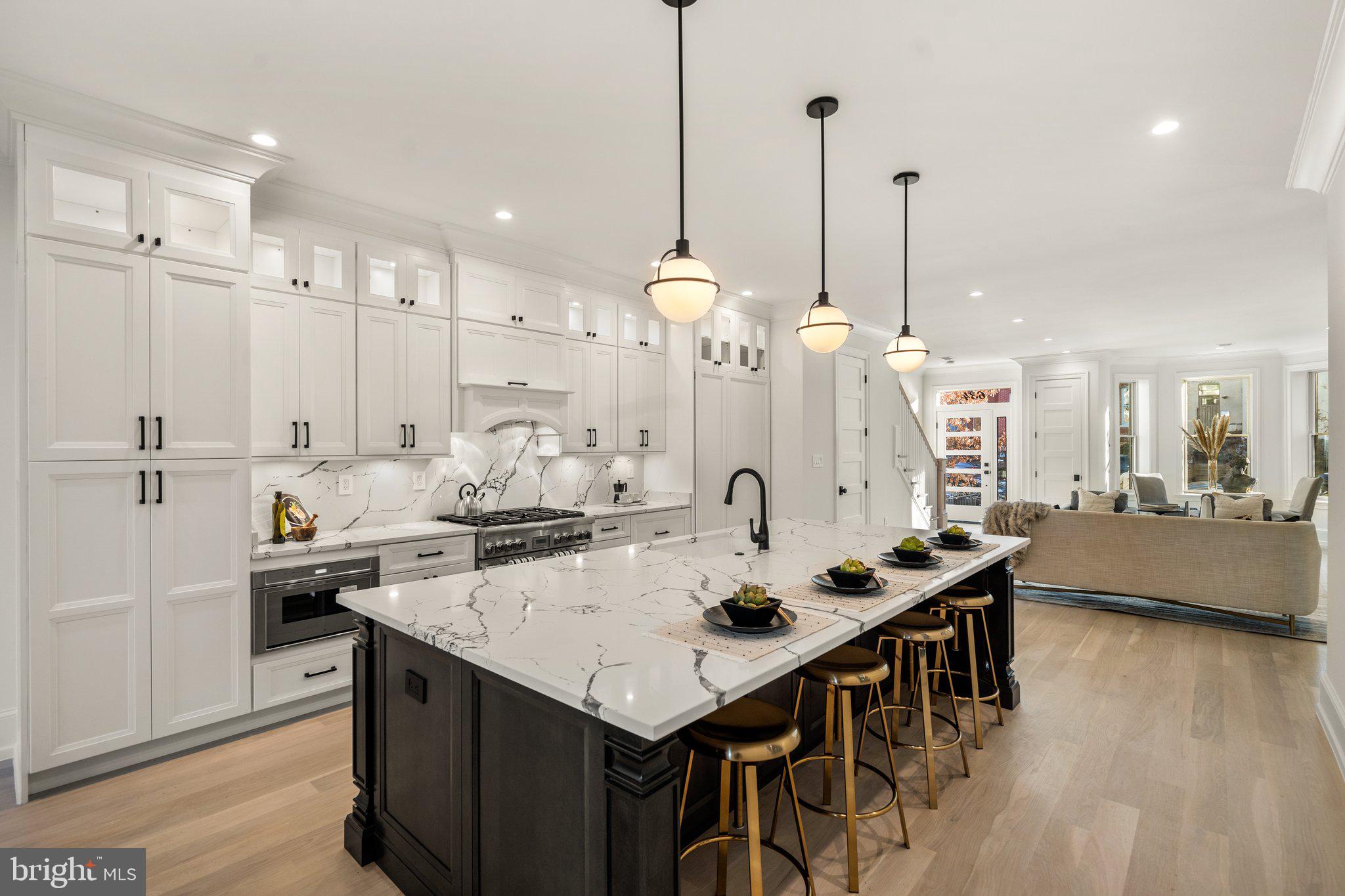634 F Street Northeast Washington, DC 20002 - Photo 12 of 57 a kitchen with stainless steel appliances kitchen island granite countertop a sink a center island and a couch