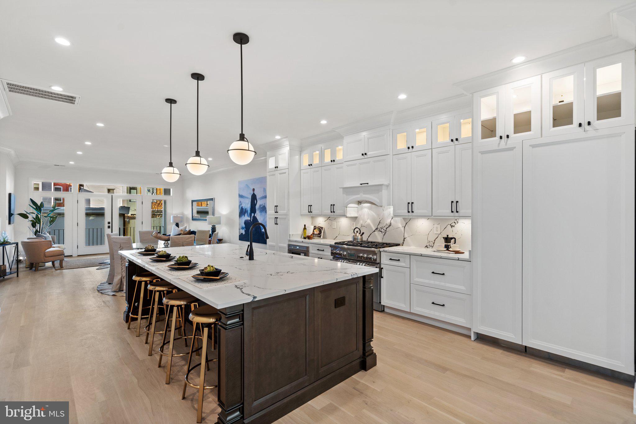 634 F Street Northeast Washington, DC 20002 - Photo 8 of 57 a large kitchen with kitchen island a stove a table a sink and a refrigerator