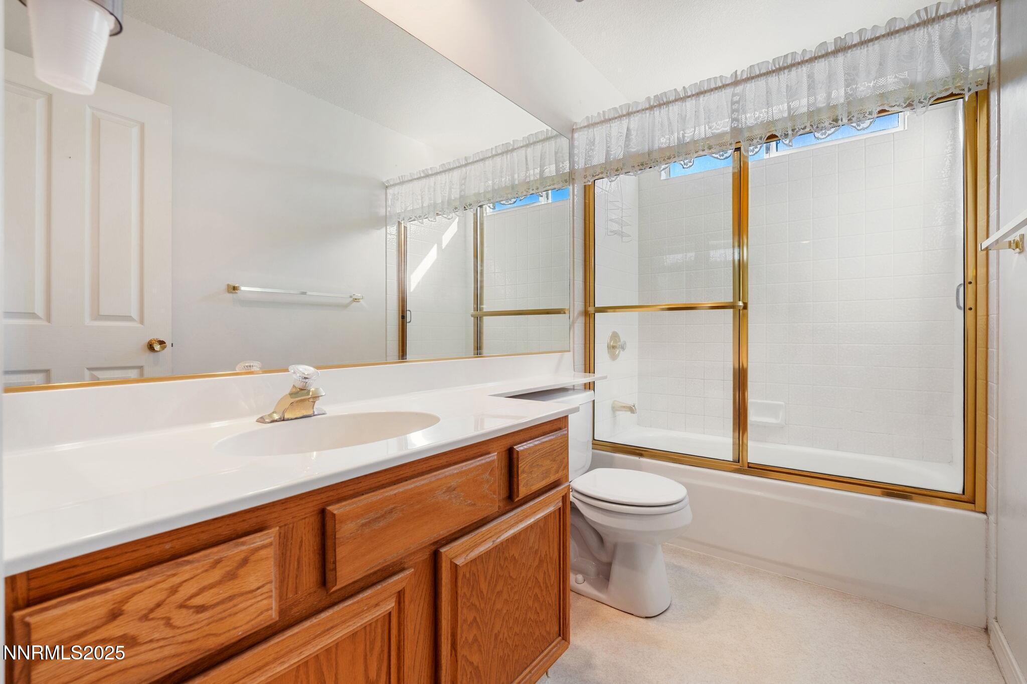 3952 Regal Drive Reno, NV 89503 - Photo 12 of 16 a bathroom with a sink a toilet and a large mirror