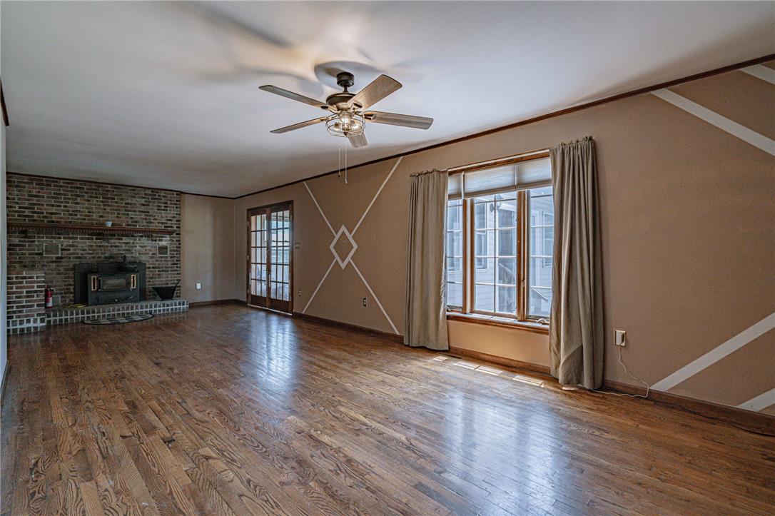 652 Old State Road Oley, PA 19547 - Photo 21 of 54 A classic brick fireplace anchors this inviting living space with polished hardwood flooring and natural light.