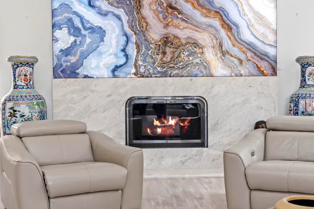 a kitchen with stainless steel appliances kitchen island granite countertop a dining table chairs and white cabinets