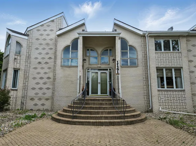 a front view of a house with a garden