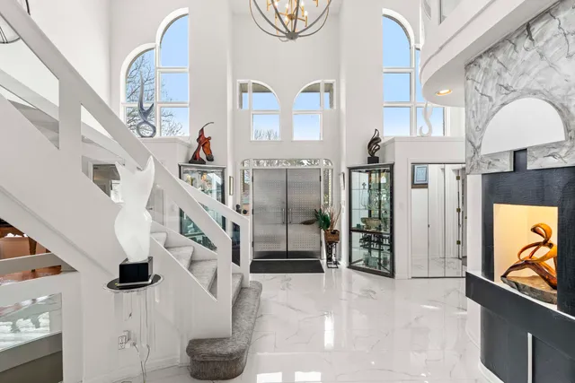 a dining room with wooden floor a chandelier a glass table and chairs