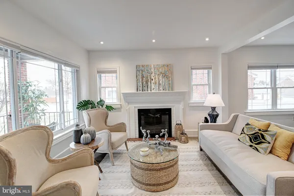 a living room with furniture fireplace and a large window