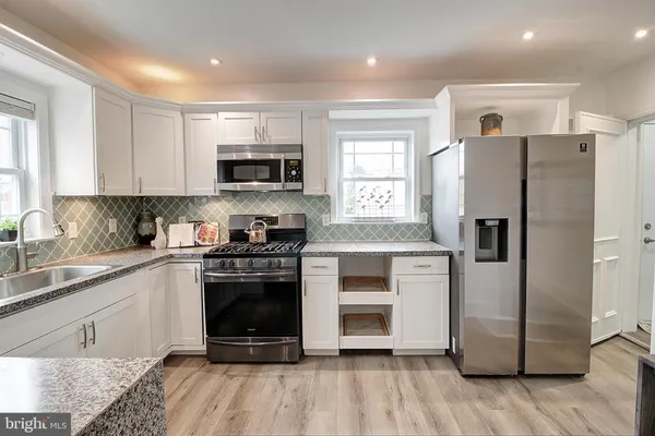 a kitchen with a refrigerator stove and sink