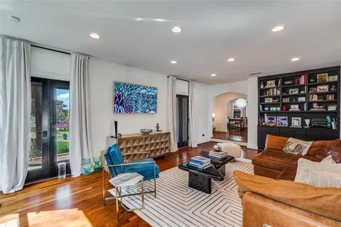 a living room with furniture kitchen view and a large window