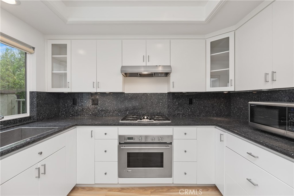37 Beachcomber Drive Corona del Mar, CA 92625 - Photo 19 of 39 a kitchen with stainless steel appliances granite countertop a stove a microwave and a white cabinets