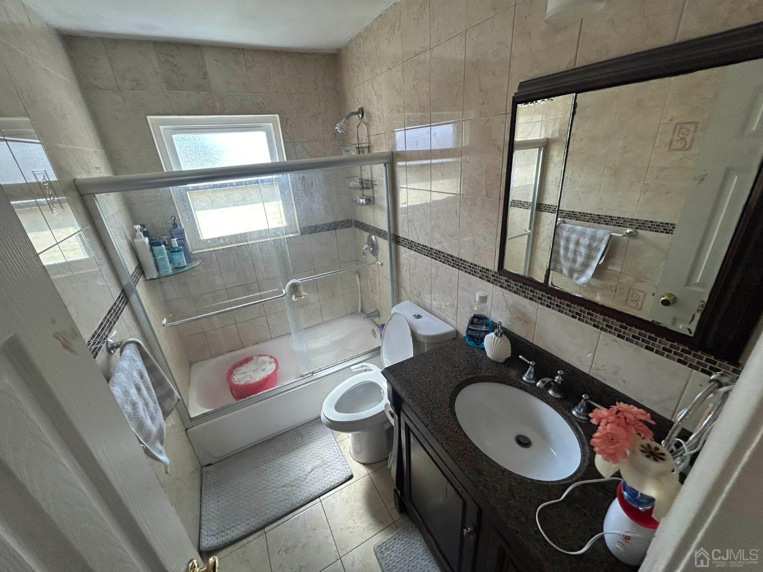 44 Judson Street, Unit 5A Edison, NJ 08837 - Photo 4 of 5 a bathroom with a granite countertop sink and a mirror
