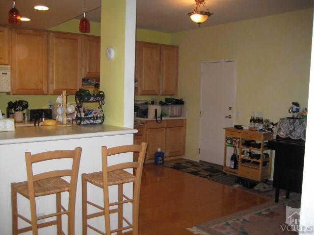 657 Cardinal Ridge Lane Simi Valley, CA 93065 - Photo 7 of 14 a kitchen with a table chairs refrigerator and cabinets