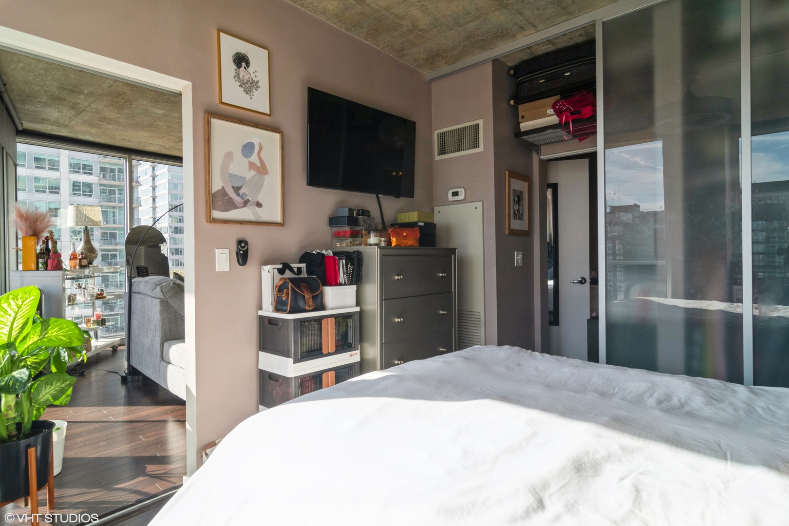 611 South Wells Street, Unit 1608 Chicago, IL 60607 - Photo 12 of 15 a bedroom with a bed and a flat screen tv