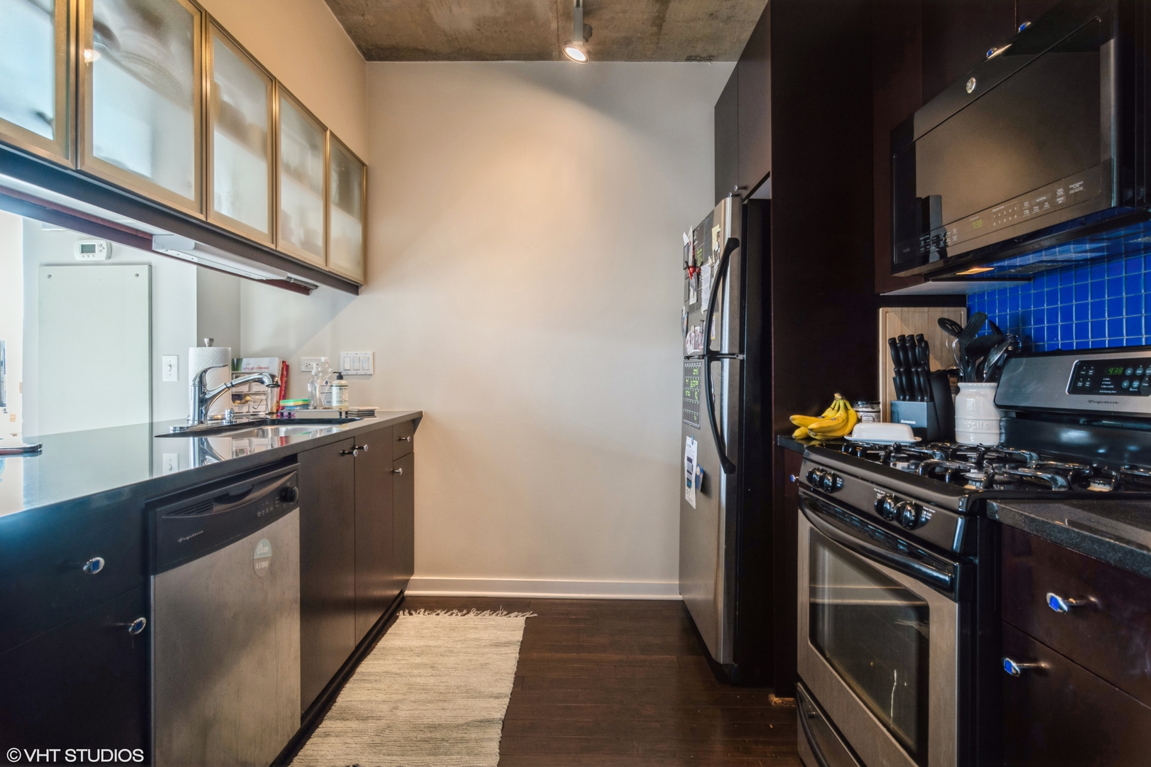 611 South Wells Street, Unit 1608 Chicago, IL 60607 - Photo 5 of 15 a kitchen with stainless steel appliances granite countertop a stove microwave and sink