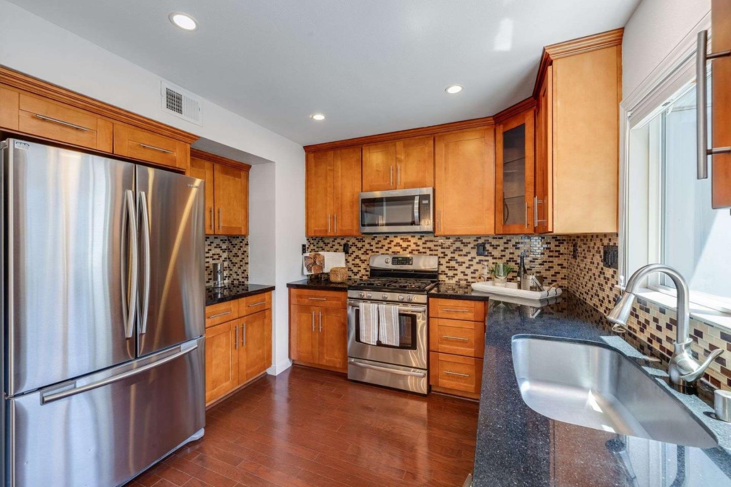 829 Montgomery Street Mountain View, CA 94041 - Photo 11 of 36 a kitchen with stainless steel appliances granite countertop a refrigerator a sink dishwasher a stove and a refrigerator with wooden floor