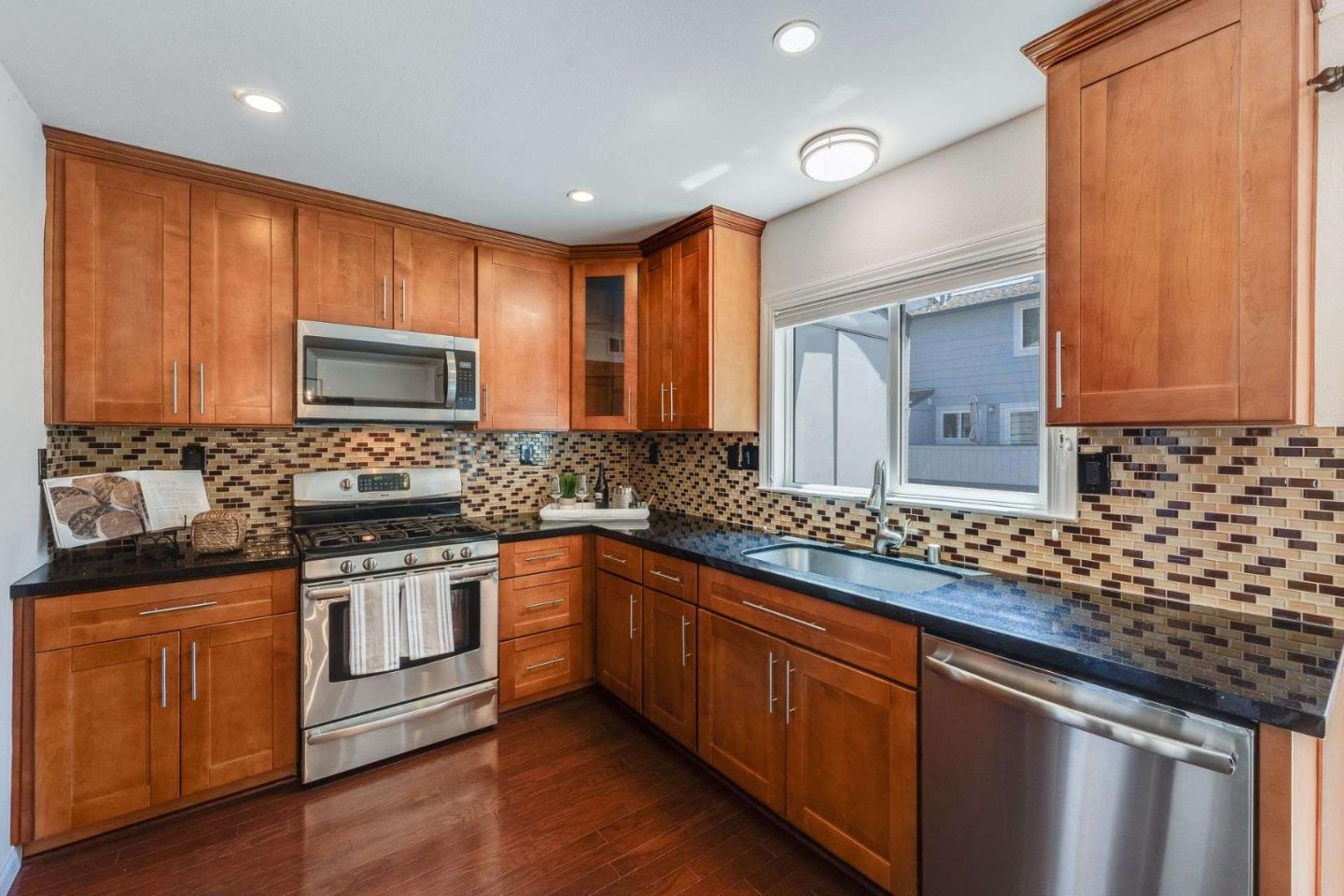 829 Montgomery Street Mountain View, CA 94041 - Photo 12 of 36 a kitchen with stainless steel appliances granite countertop wooden cabinets a stove a sink and dishwasher with wooden floor
