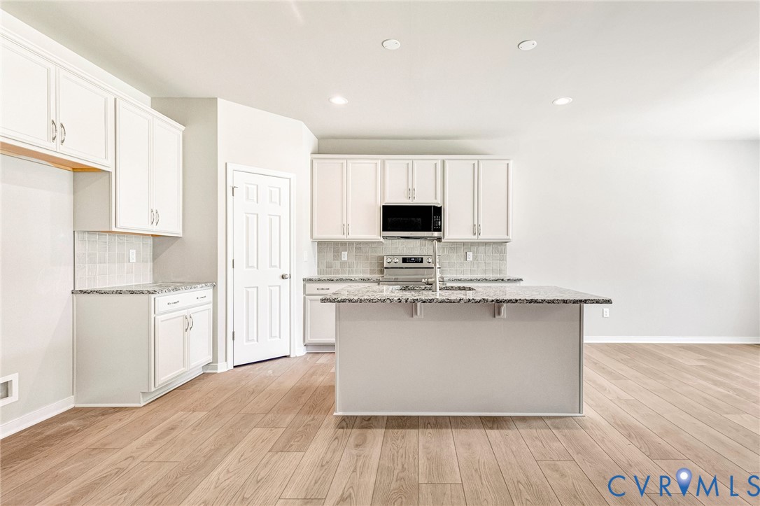 10010 Cool Spring Road Mechanicsville, VA 23116 - Photo 4 of 13 Kitchen featuring white cabinetry, light wood-fini