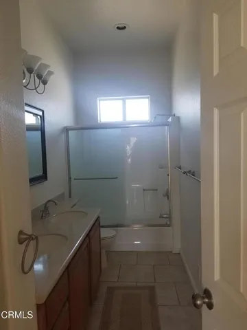 a bathroom with a sink a toilet a mirror and shower