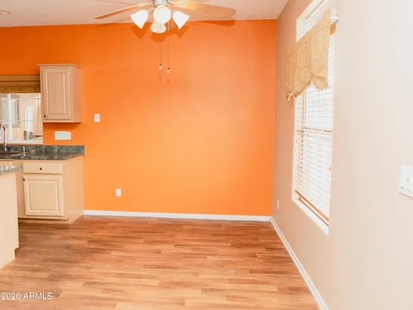 an empty room with a window and a ceiling fan