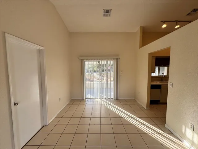 a view of a hallway with wooden floor and a bathroom