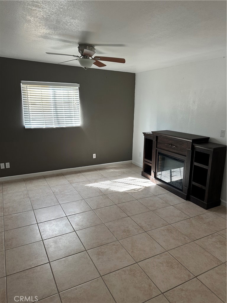 740 West Church Avenue Ridgecrest, CA 93555 - Photo 8 of 11 a view of an empty room with a fireplace and a window
