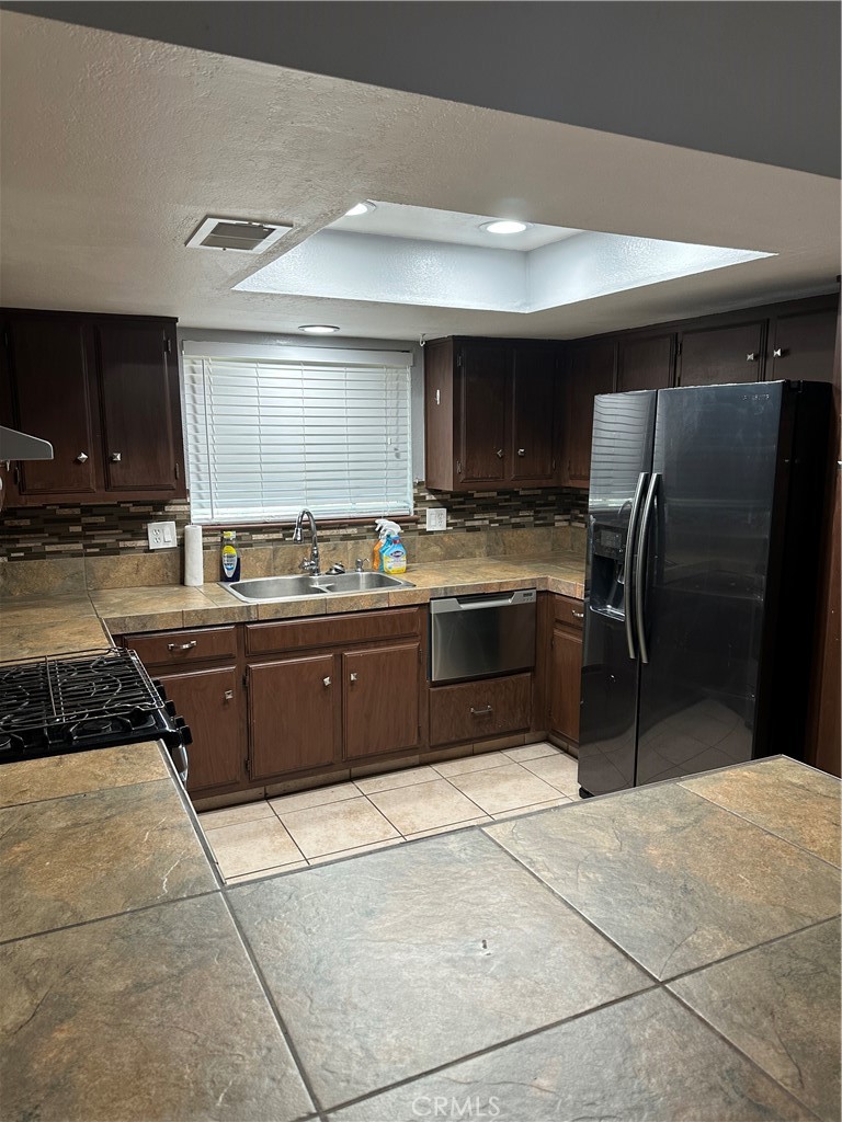 740 West Church Avenue Ridgecrest, CA 93555 - Photo 10 of 11 a kitchen with stainless steel appliances granite countertop a stove a sink and a refrigerator