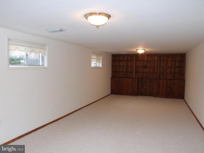 14211 Chesterfield Road Rockville, MD 20853 - Photo 15 of 28 Recreation Room with New Carpet and Bookshelves