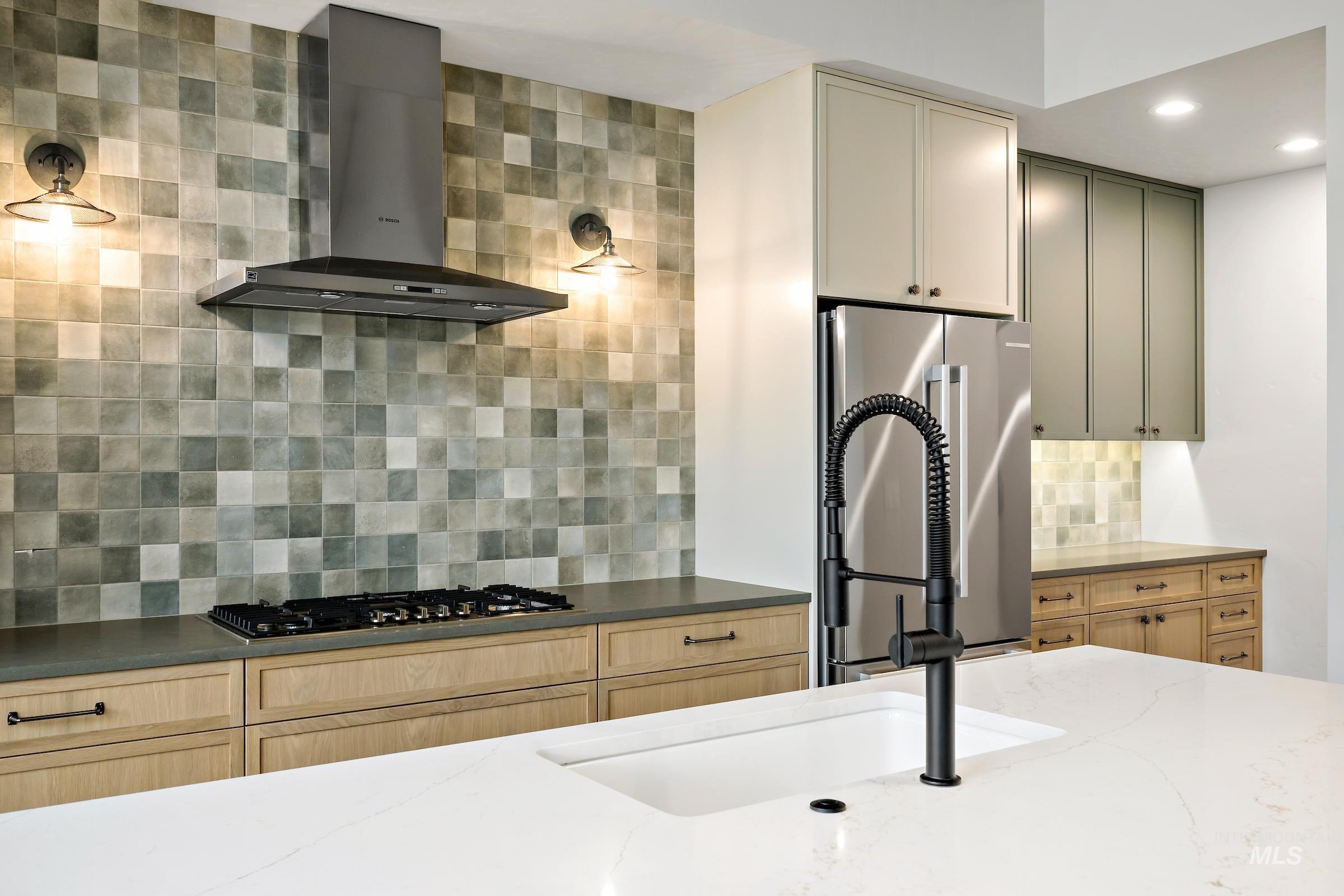 11696 North Rabbitbrush Way Boise, ID 83714 - Photo 13 of 32 Kitchen with wall chimney exhaust hood, tasteful backsplash, dark stone counters, freestanding refrigerator, and gas cooktop