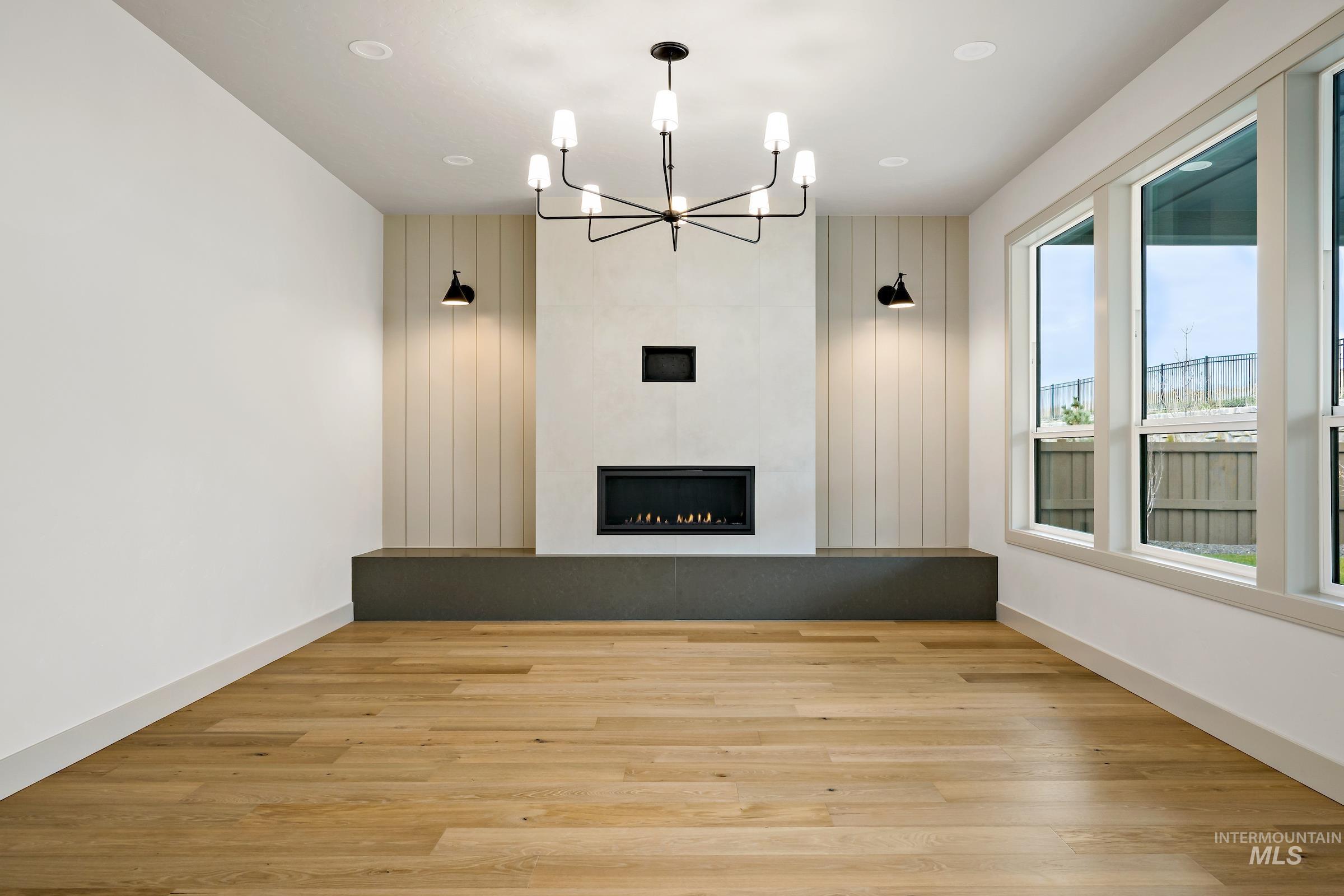 11696 North Rabbitbrush Way Boise, ID 83714 - Photo 14 of 32 Unfurnished living room with a chandelier, light wood-style flooring, and a fireplace
