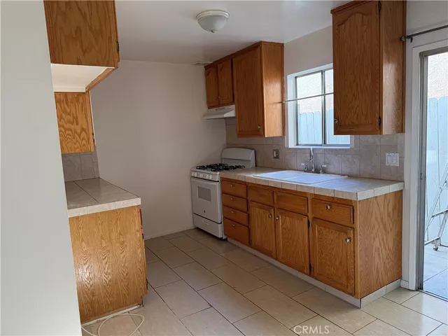 a kitchen with a sink a stove and cabinets