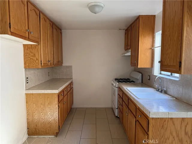 a kitchen with a sink stove and cabinets