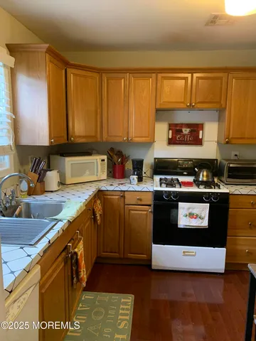 a kitchen with stainless steel appliances granite countertop a stove a sink and a microwave