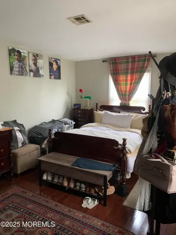 a bedroom with a bed window and a flat screen tv