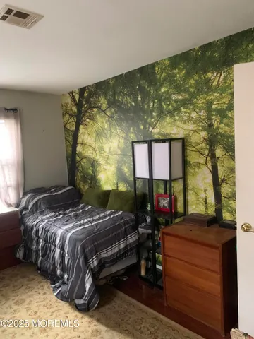 a bedroom with a bed window and a table in it