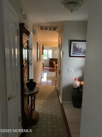 a view of a hallway and a livingroom with furniture