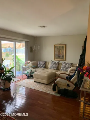 a living room with furniture floor to ceiling window and a flat screen tv