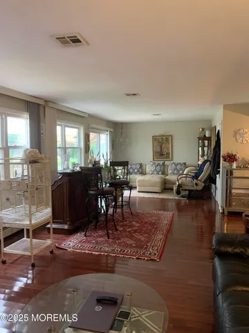 a living room with furniture a rug and a dining table