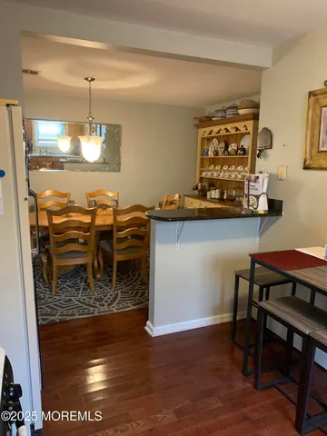 a kitchen with a table chairs and a wooden floor