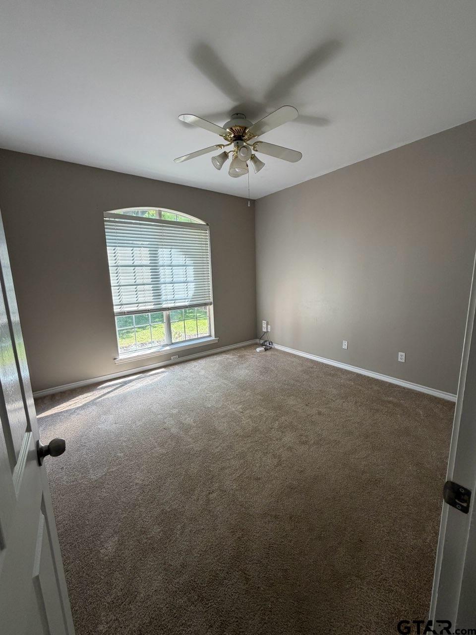 3204 Pebblebrook Circle Tyler, TX 75707 - Photo 10 of 18 an empty room with windows and ceiling fan