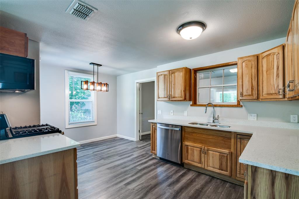 606 West High Street Terrell, TX 75160 - Photo 9 of 28 a kitchen with stainless steel appliances granite countertop a sink stove and refrigerator