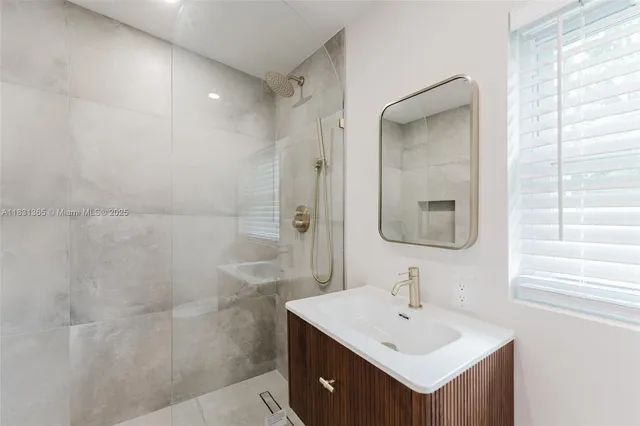 a bathroom with a sink mirror and a shower