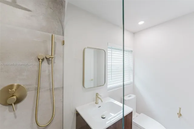 a bathroom with a sink and mirror with toilet